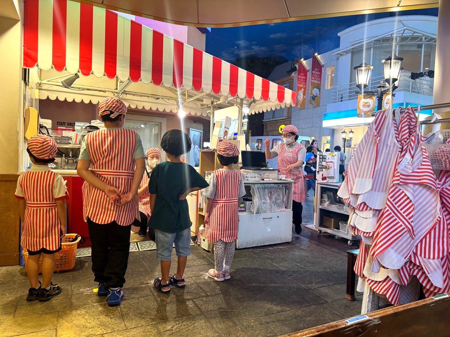 キッザニア東京のソフトクリームショップ。赤と白のストライプの制服を着た子どもたちが並んでいる